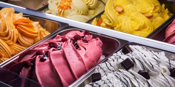 Italian gelato of various flavors (vanilla, chocolate, raspberry, strawberry, pistachio, lemon, orange, yogurt...) in ice cream parlor.